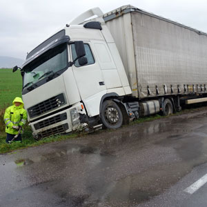 A truck is falling on the side of the road.